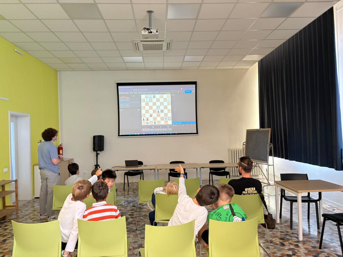 Il gruppo dei ragazzi segue la lezione con la scacchiera proiettata sullo schermo